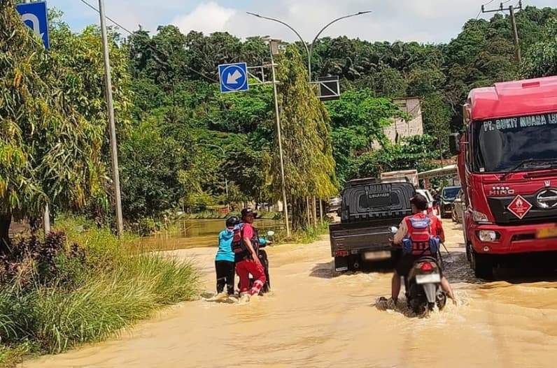 Petugas Damkar dan Penyelamatan Kukar melakukan pengaturan lalu lintas saat banjir merendam Jalan Poros Jalur Dua Tenggarong-Samarinda KM 8, Desa Bukit Raya, Tenggarong Seberang, Selasa (9/6/2026). (Foto: Damkar Tenggarong Seberang)