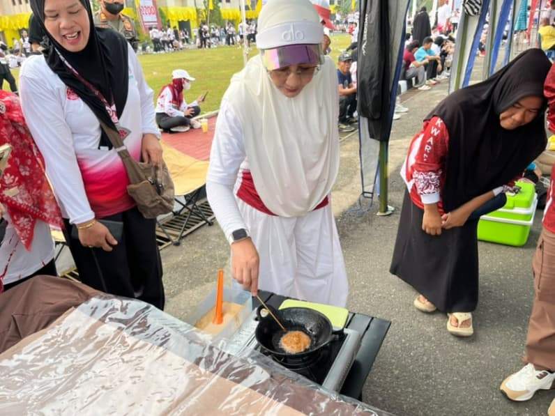 Bupati Berau ikut membuat kue cucur di stand Pramuka saat kegiatan Bupati Berau Independence Runs (BBIR) 2026 di halaman Kantor Bupati Berau. (Foto: Nur Hidayah/ pusaranmedia.com)