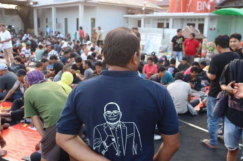 Terlihat Kasmidi Bulang membelakangi kamera saat menyaksikan lomba domino di kediamannya Jalan Ilham Maulana Polder Sangatta Kutai Timur. (Foto: Istimewa)