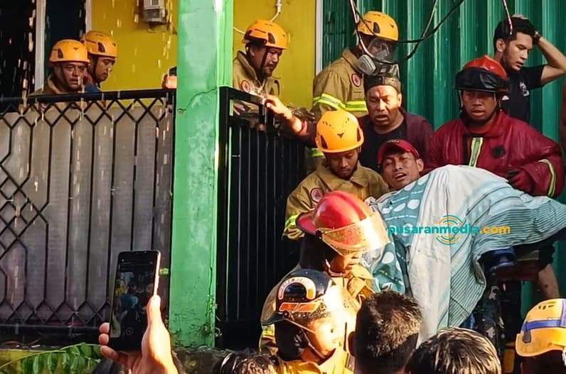 Petugas membawa seorang anak yang terbakar dari lantai dua rumah di Jalan Sulawesi Gamb Buntu RT 45 Kelurahan Karang Rejo, Rabu (26/8/2026). (Foto: Achmad Fadillah/Pusaranmedia.com)