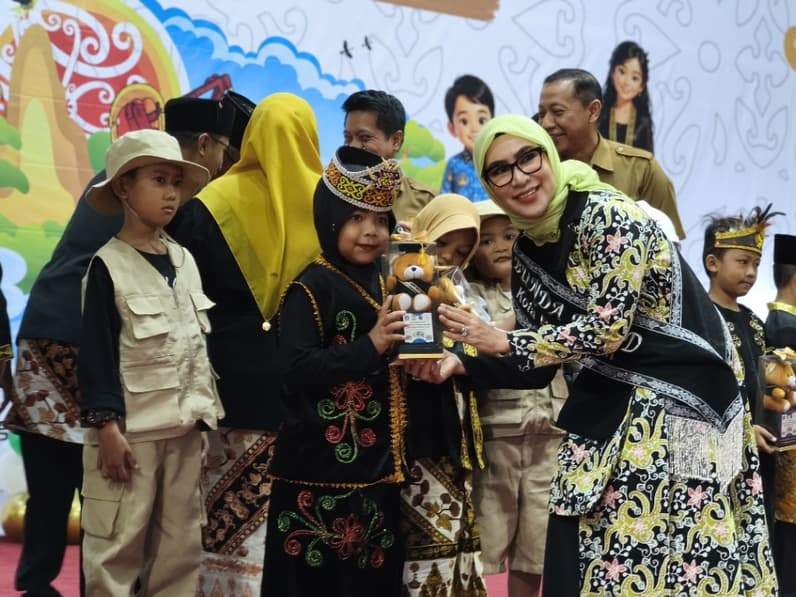 Ketua Bunda PAUD Balikpapan, Nurlena Rahmad Mas'ud menyerahkan boneka kepada salah satu anak saat kegiatan Pentas Seni Kelompok Bermain SKB se-Kota Balikpapan di BSCC Dome, Senin (19/5/2026). (Foto: Achmad Fadillah/Pusaranmedia.com)