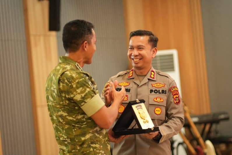 Kapolres Kutim, AKBP Aryansyah saat menyerahkan cendera mata kepada Komandan Danbrigif TP 32/Mangkalihat, Kolonel Infanteri Agussalim. (Foto: Dok Polres Kutim)