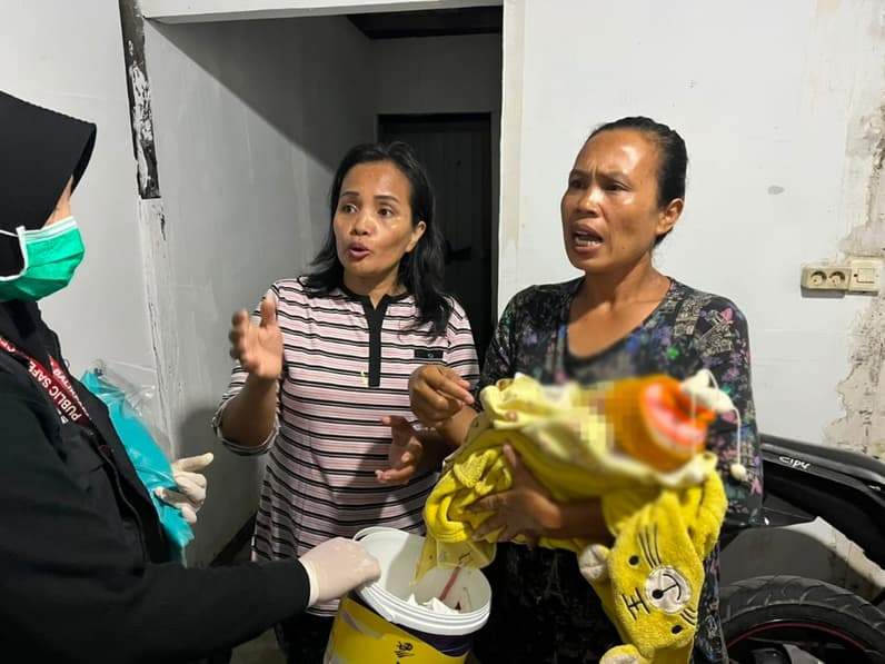 Warga menggendong bayi yang ditemukan di Gang Villa Kelurahan Damai Bahagia, Rabu (22/7/2026). (Foto: Polsek Balikpapan Selatan)