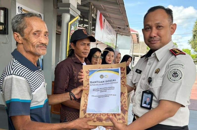 Kepala Rutan Tanah Grogot menyerahkan paket bansos kepada salah satu keluarga WBP yang membutuhkan. (Foto: Dok.Rutan Tanah Grogot)
