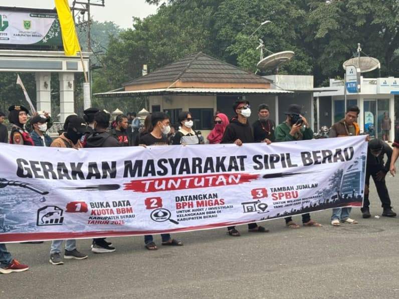 Gerakan Masyarakat Sipil Berau membentangkan spanduk berisi tuntutan keterbukaan data kuota BBM di halaman Kantor Bupati Berau. (Foto: Nur Hidayah/ pusaranmedia.com)