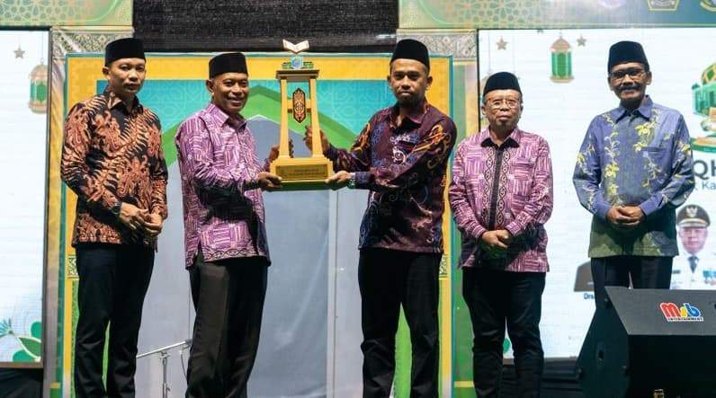 Saat Sekda Paser Katsul Wijaya menyerahkan piala bergilir MTQH Paser ke pemenang MTQH ke-50 Paser. (Foto : DKISP Paser)