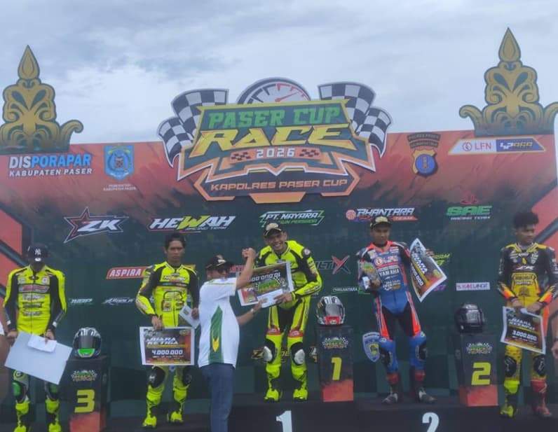 Wabup Paser Ikhwan Antasari menyerahkan piagam, piala dan uang pembinaan kepada juara pertama kelas 150 CC empat tak Alfi Husni dari Hewah Racing Team dalam ajang Paser Cup Race 2026 - Kapolres Paser Cup. (Foto: Luthfi/Pusaranmedia.com)