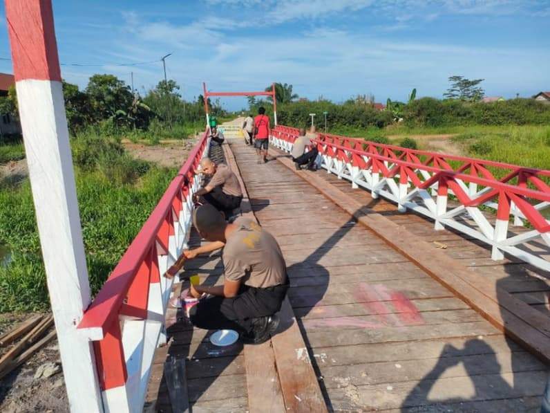 Giat Polres Kutim mengecat jembatan merah putih program Polri. (Foto: Dok Polres Kutim)
