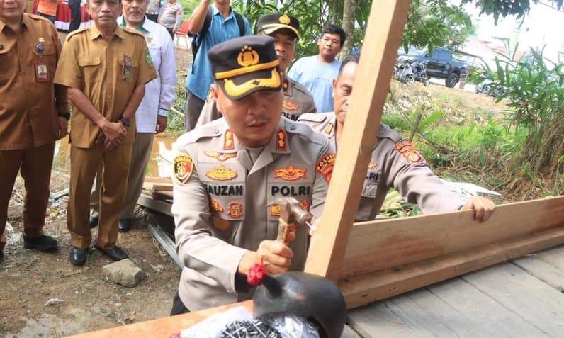 Terlihat Kapolres Kutai Timur, AKBP Fauzan Arianto SH., S.I.K., MH saat memaku dinding yang dibedah di Sangatta. (Foto: Dok Polres Kutim)