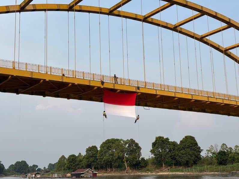 Pengibaran bendera merah putih di jembatan pela. (Foto: Wamapala Unikarta)