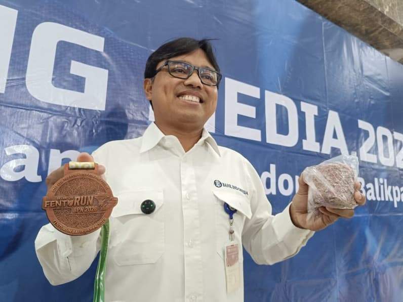 Kepala Perwakilan BI Balikpapan, Robi Ariadi memperlihatkan medali FENTURUN yang terbuat dari limbah racik uang kertas, Rabu (23/8/2026). (Foto: Achmad Fadillah/Pusaranmedia.com)
