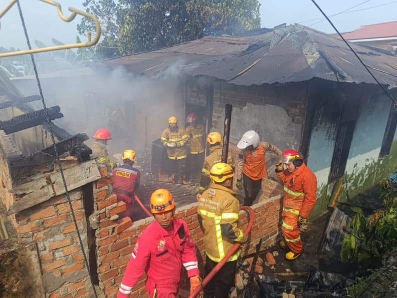 Petugas pemadam kebakaran melakukan pendinginan dan korban ditutupi seng sebelum dievakuasi, Kamis (22/10/2026). (Foto: Achmad Fadillah/Pusaranmedia.com)