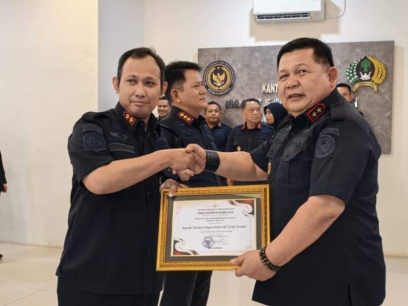 Kepala Rutan Tanah Grogot Aris Triyanto (kiri) menerima piagam penghargaan yang diserahkan Kepala Kantor Wilayah Ditjenpas Kaltim Endang Lintang Hardiman (kanan). (Foto: Dok Rutan Tanah Grogot)
