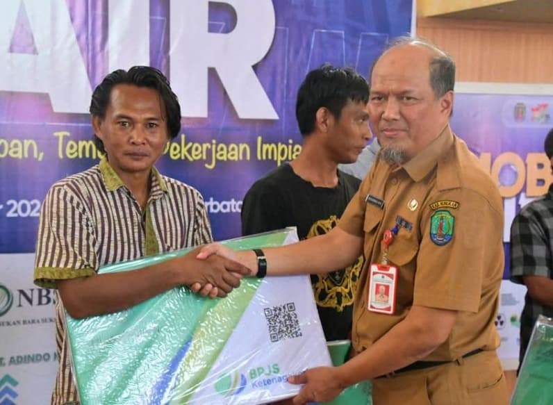 Asisten 1 Setkab Nunukan Muh Amin saat menyerahkan kartu BPJS Ketenagakerjaan kepada para pekerja di Nunukan. (Foto: Diansyah/Pusaranmedia.com)