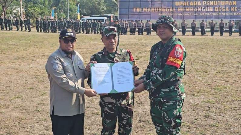 Saat Dandim 0904/Psr, Edy Wahyu Satriyadi menyerahkan dokumen hasil pelaksanaan TMMD 129 di Desa Biu kepada Wabup Paser, Ikhwan Antasari. (Foto: Luthfi/Pusaranmedia.com)