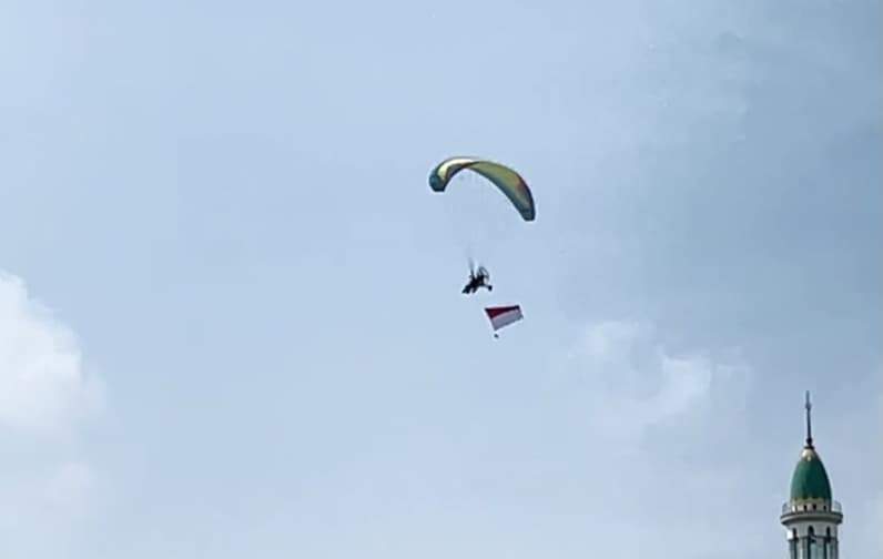 Terlihat atlet paramotor bawa bendera merah putih di atas langit pada HUT ke-81 RI di Kutai Timur. (Foto: Siswandi/Pusaranmedia.com)
