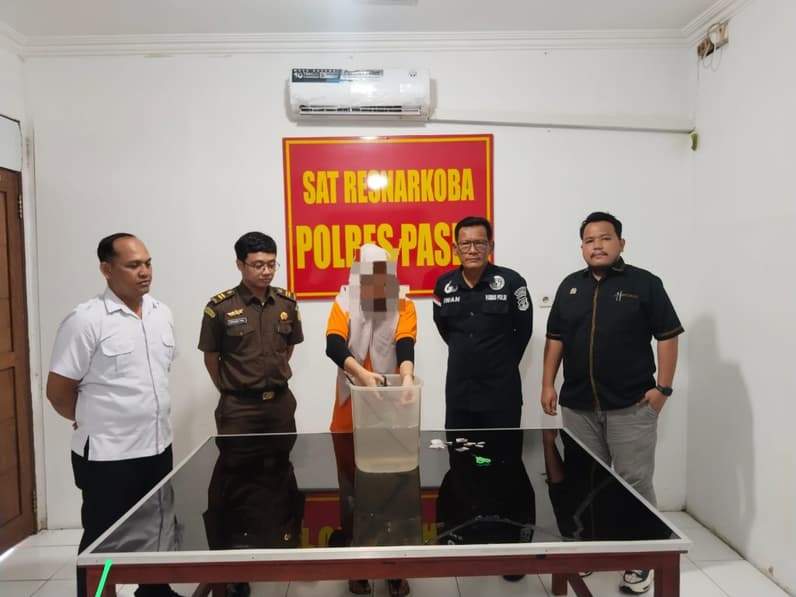 Salah satu tersangka melarutkan barang bukti sabu ke dalam air dalam wadah plastik transparan. (Foto: Dok.Polres Paser)