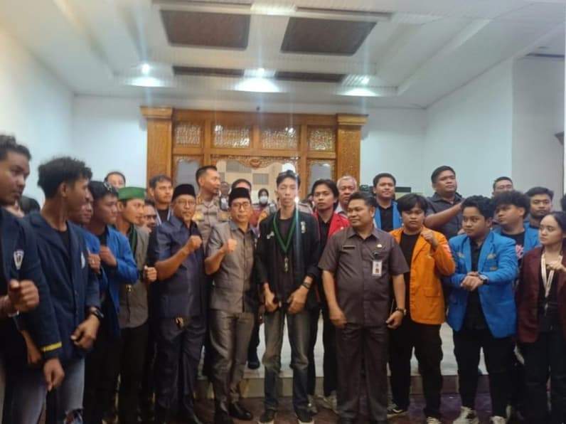 Massa aksi unjuk rasa mengabadikan foto bersama pejabat usai pernyataan janji pertemuan selanjutnya di Balaikota Balikpapan, Senin (15/6/2026). (Foto: Achmad Fadillah/Pusaranmedia.com)