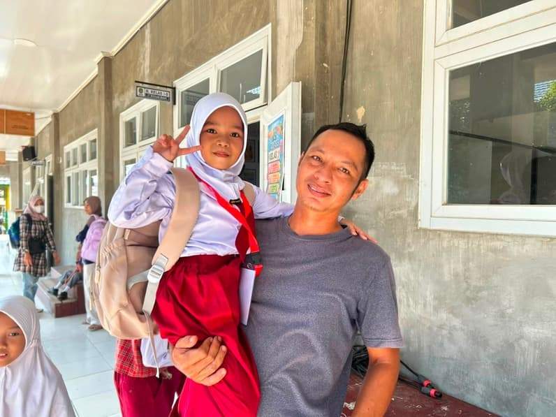 Potret Deni saat mengantar buah hatinya ke sekolah SDN 4 Tenggarong (Foto: Aswin/pusaranmedia.com)