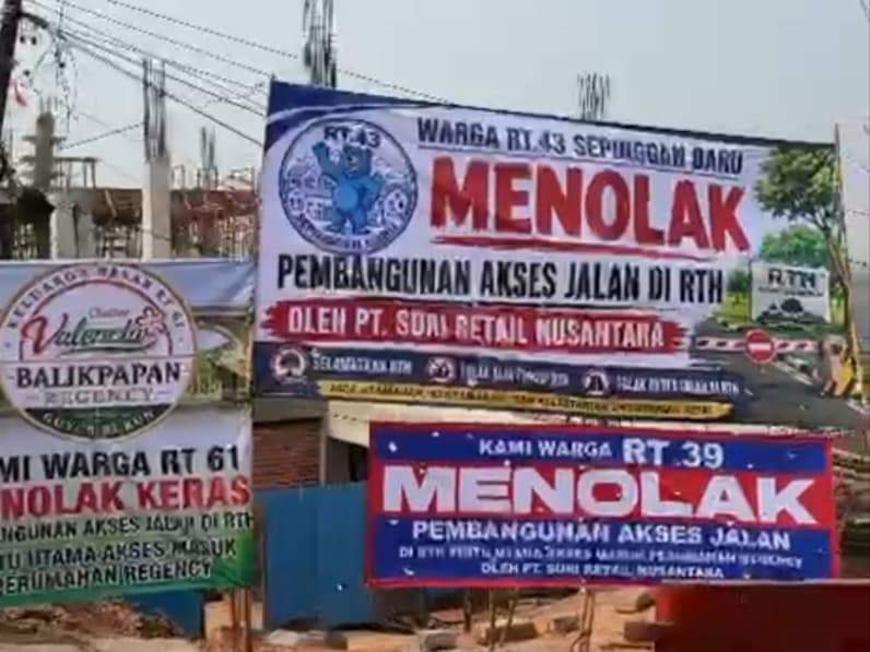 Warga Perumahan Balikpapan Regency membentangkan spanduk penolakan bangun di pintu masuk utama perumahan. (Foto: Tangkapan layar video/Forum RT Balikpapan Regency)