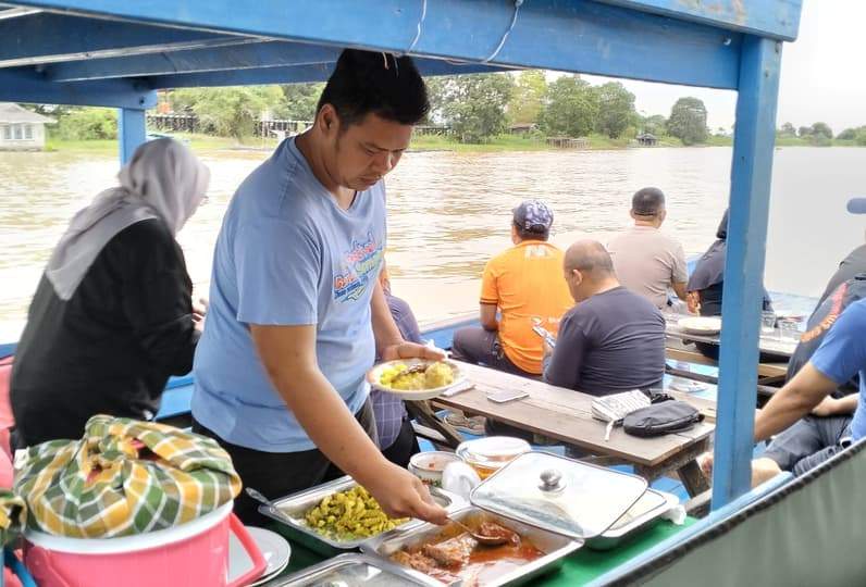 Wisatawan menikmati sarapan pagi di atas perahu menyusuri Sungai Pela dengan pemandangan alam yang masih asli (Foto: Bambang Irawan)