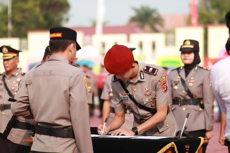 Terlihat Kapolres Kutim, AKBP Aryansyah menyakasikan Kasat Reserse Kriminal baru, Raden Bagoes (baret merah) saat bertanda tangan. (Foto: Dok.Polres Kutim)