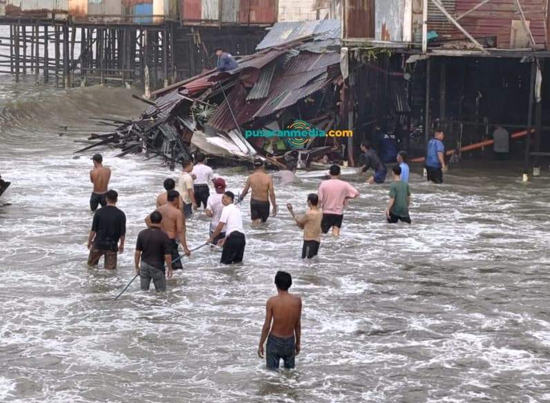 Warga membantu evakuasi rumah di kawasan pesisir RT 9 Kelurahan Klandasan Ulu, Kecamatan Balikpapan Kota, Jumat (10/7/2026). (Foto: Achmad Fadillah/Pusaranmedia.com)