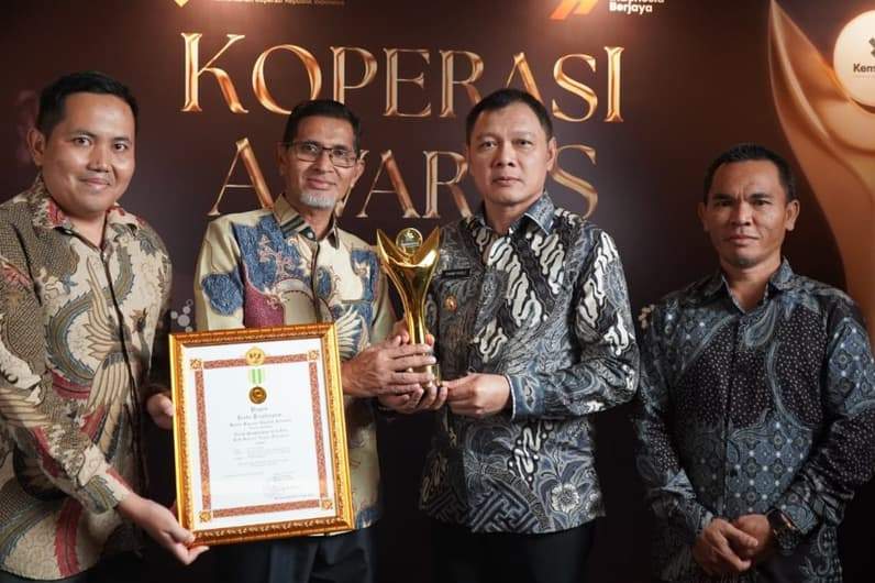 Bupati Paser, dr Fahmi Fadli (dua dari kanan) bersama Kepala Disperindagkop dan UMKM Paser, Yusuf (dua dari kiri), sembari memegang trofi pengharapan Bakti Koperasi Nayaka Mahambara 2026. (Foto : Dok Prokopim Paser)
