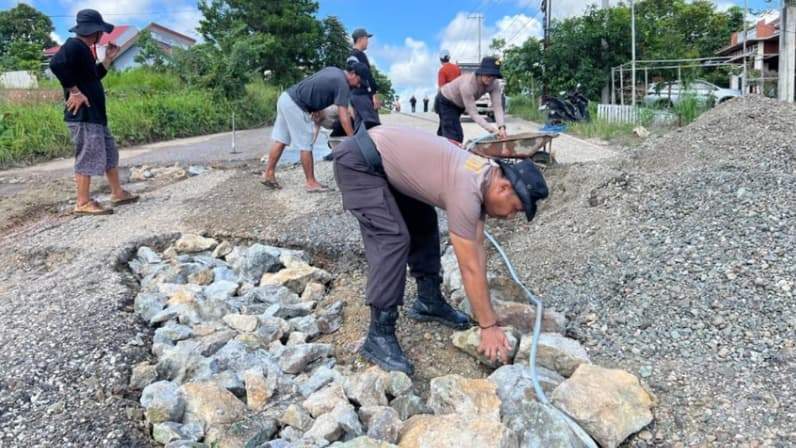 Saat Polsek Tanah Grogot gotong royong bersama warga untuk memperbaiki jalan rusak di Jalan Ridwan Suwidi, Kecamatan Tanah Grogot. (Foto : Dok Polsek Tanah Grogot)