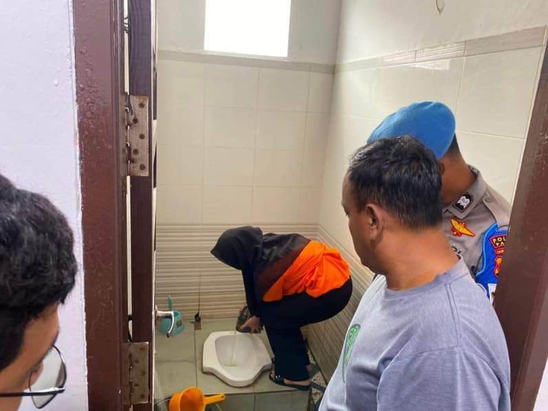 Prosesi pemusnahan barang bukti ekstasi ke dalam kloset yang dilakukan tersangka. (Foto: Dok.Satresnarkoba Polres Paser)