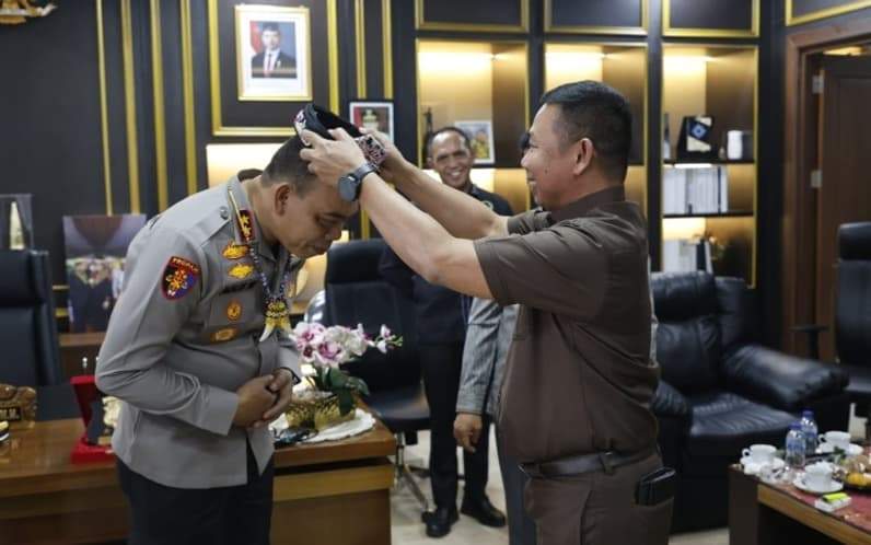 Wakil Ketua II DPRD Kaltara, Muddain saat mengenakan sesingal kepada Kapolda Kaltara. (Foto : Istimewa)