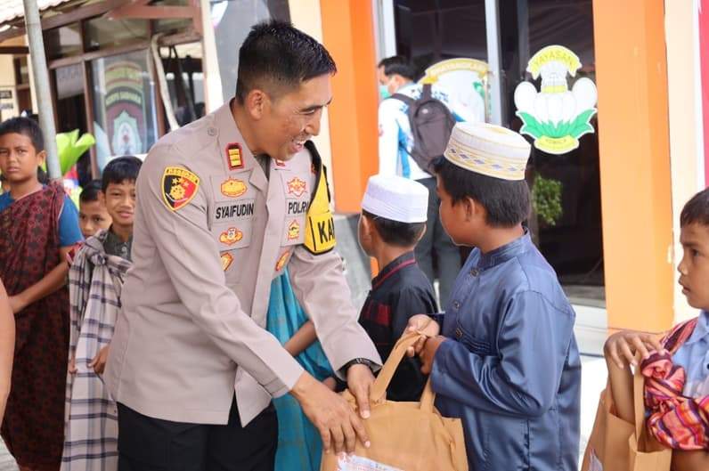 Kapolsek Penajam, AKP Syaifudin memberikan bingkisan kepada anak yang mengikuti khitanan massal. (Foto: Humas Polres PPU).