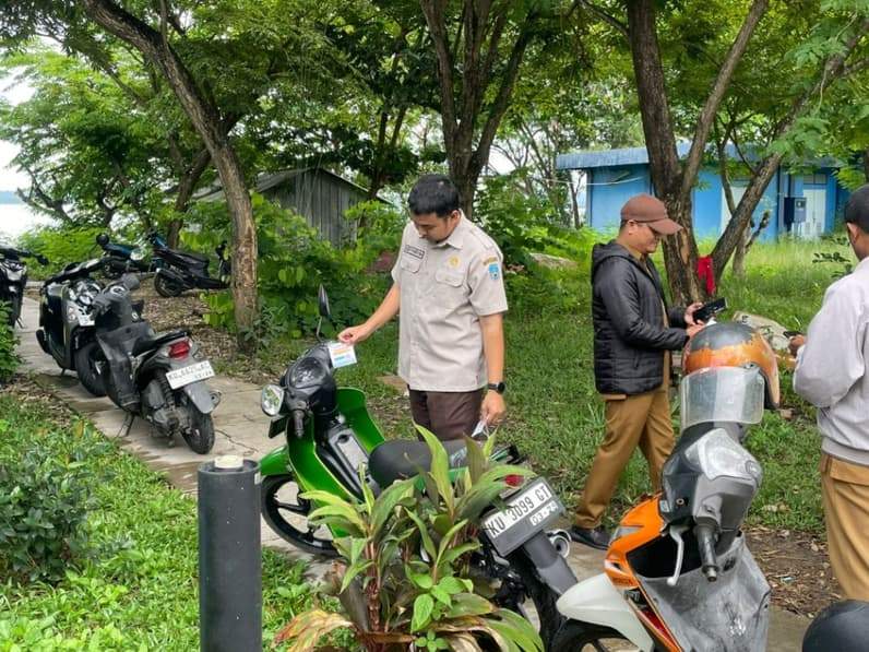 Petugas UPTD Dispenda Kaltara Wilker Nunukan menempelkan stiker pembayaran pajak. (Foto: Diansyah/Pusaranmedia.com)