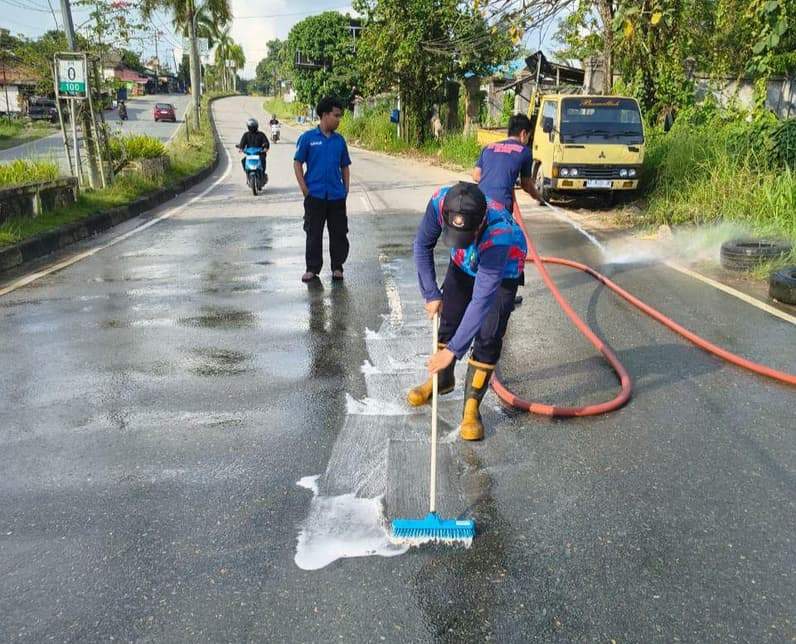 Pembersihan tumpahan minyak oleh disdamkarmatan di jalur dua tenggarong-samarinda. (Foto: Disdamkarmatan Kukar)