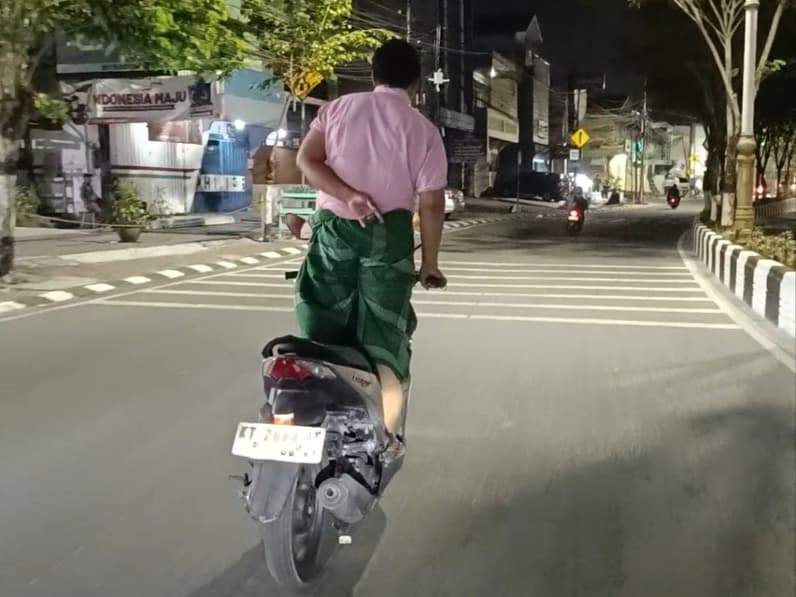 Seorang pria dewasa mengendarai sepeda motor sambil berdiri di Jalan Ahmad Yani, Rabu (7/10/2026). (Foto: Achmad Fadillah/Pusaranmedia.com)