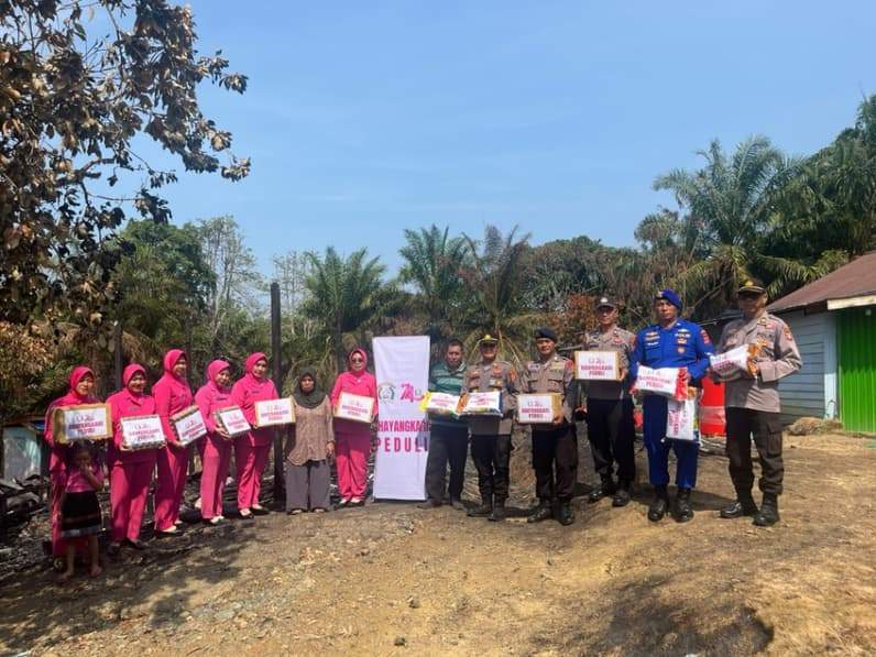 Polsek Kuaro bersama Bhayangkari saat memberikan bantuan kepada korban kebakaran di Desa Lolo. (Foto : Dok Polres Paser)
